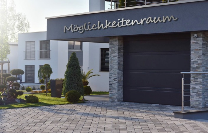 Dies ist ein Bild wo mit Metallbuchstaben aus Edelstahl mit dem Firmennamen MÖGLICHKEITENRAUM in 3,60 Meter lang