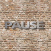 Dies ist ein Bild mit Edelstahlbuchstaben an einer Klinkerwand. Die Einzelbuchstaben zeigen das Wort PAUSE