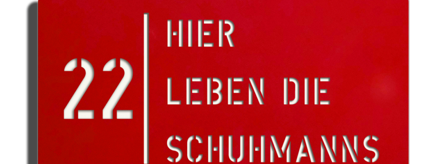 Dies ist ein Bild von einem - Hier leben die Schild - mit weiß glänzender Oberfläche und roter Schriftfarbe