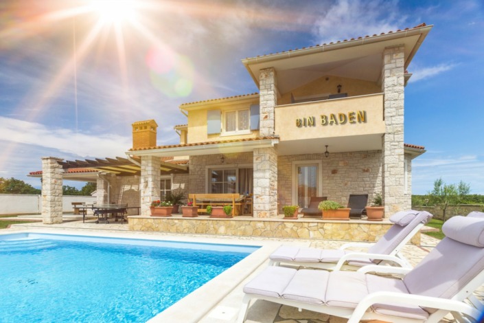 Dies ist ein Bild eines großen Metall Schriftzug in Aluminium gelb | BIN BADEN an einem Poolhaus
