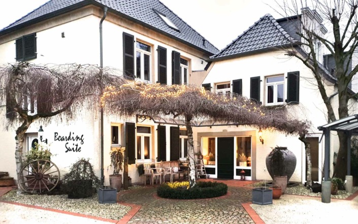 Dieses Bild zeigt den Metall Schriftzug BOARDING SUITE an der Fassade des Markenshop für Hausschilder
