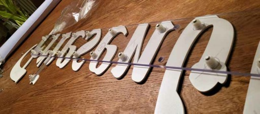 Dieses Bild zeigt die Montagevorrichtung der Schriftzüge mittels Wandhalterung in Form einer Acrylglasschiene
