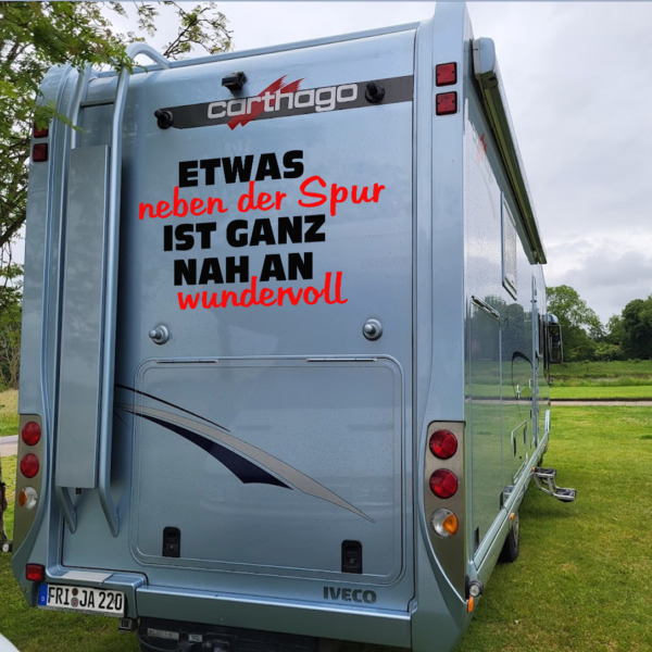 Dies ist ein Bild mit einem Sprüche-Aufkleber als Schriftzug auf einem Wohnmobil